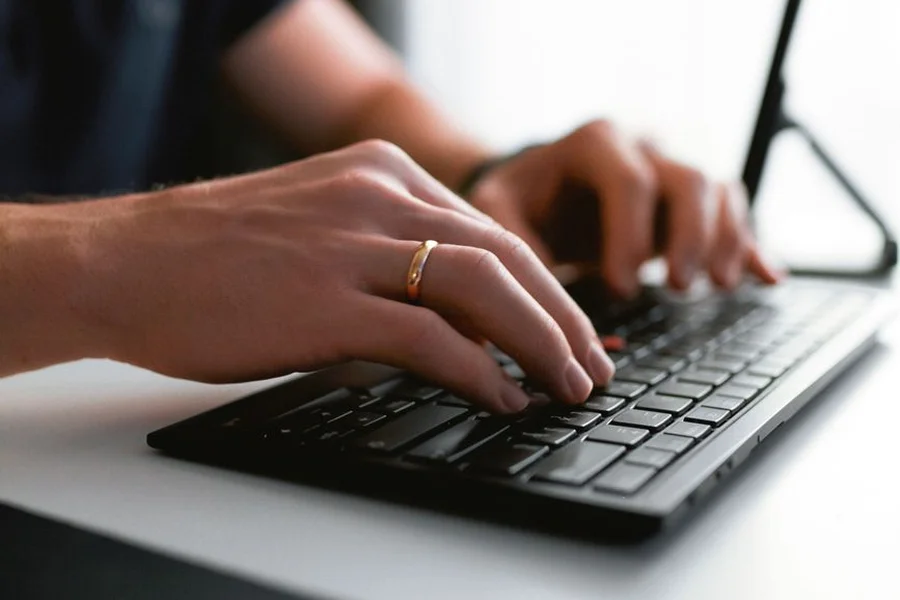 A computer programmer typing fast on a sleek keyboard using terminal shortcuts